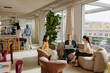 © BONNINSTUDIO/Stocksy - Business people having informal meeting in modern office lounge