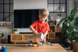 © Santi Nuñez/Stocksy - Little boy playing with wooden educational toy tools at home