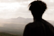 © Adrian Rodd/Stocksy - Volcanic mountains with the silhouette of a man gazing at horizon