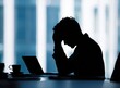 © Nasra - Silhouette of stressed businessman at desk