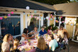 © Johnér - High angle view of male and female family friends having dinner in back yard during social gathering
