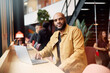 © Johnér - Portrait of bald male entrepreneur sitting with laptop at table in office