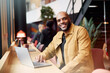 © Johnér - Portrait of smiling bald male business professional sitting with laptop at table in office