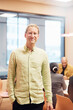 © Johnér - Portrait of smiling male entrepreneur standing with hand in pocket at office board room