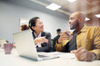 © Johnér - Smiling mature businesswoman talking with male coworker sitting at desk in office