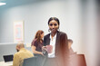 © Johnér - Portrait of smiling young female entrepreneur holding coffee mug standing in office