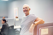 © Johnér - Portrait of smiling short haired female entrepreneur leaning on desk in office