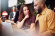 © Johnér - Bald businessman discussing strategies with female coworker while using laptop in office