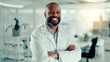 © peopleimages.com - African man, arms crossed and smile at lab with pride for medical research, study and portrait. Mature person, scientist and happy with confidence for pharma development for vaccine in Nigeria