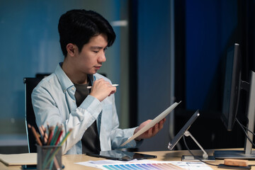 Male coder or developer working overtime using a computer display in problem solving at workplace.