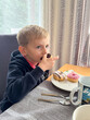 © Elena - Child Enjoying Donuts at the Breakfast Table