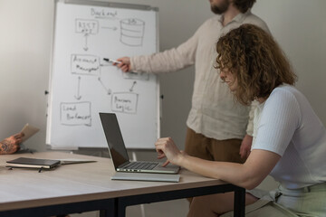 three software developers brainstorming in a modern office. team coding session with laptops showing