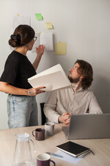three software developers brainstorming in a modern office. team coding session with laptops showing