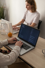 three software developers brainstorming in a modern office. team coding session with laptops showing
