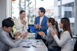 © Wasana - A group of people are clapping in a meeting room