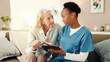 © peopleimages.com - Tablet, sofa and nurse with senior woman for medical service, consulting and talking. Retirement home, healthcare and caregiver with patient on digital tech for results, diagnosis or assisted living