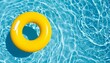 © Nashihal - yellow swimming pool ring float in blue water. concept summer background, top view with copyspace