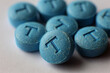 © Stock'd  - pile of blue pressed pills with T embossed on each, testosterone themes
