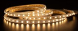 Flexible LED strip lights coiled on a dark surface for versatile lighting solutions in home decor