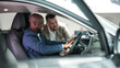 © wedmoments.stock - A customer at a car dealership consults with a salesperson, choosing a new vehicle. Concept a trusting dialogue between the buyer and the consultant.