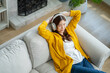 © Yingyaipumi - Happy young asian woman use headphones and relaxing at home.Female smile sitting on sofa,couch and holding mobile smartphone.Listening to music on lazy and relaxed day at winter