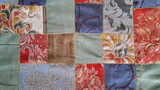 Colorful patchwork fabric with baroque and floral patterns sewn from textured upholstery pieces