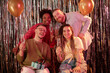 © Seventyfour - Diverse group of young adults and middle aged man celebrating birthday, smiling and holding champagne glasses, one Caucasian man in wheelchair with disability holding gift box