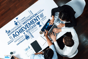 Leinwandbilder - Aerial view of a diverse team collaborating over a table, surrounded by words symbolizing achievement, motivation, and success, emphasizing growth and strategic planning. Amity