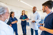 © unai - Medical team discussing patient charts during hospital meeting