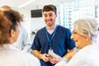 © unai - Medical team discussing patient care in hospital corridor
