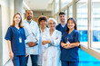 © unai - Medical team posing in hospital corridor, healthcare professionals united