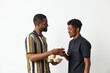 © SHOTPRIME STUDIO - Two smiling black men sharing a coffee moment, dressed casually in stylish attire, creating a warm and friendly atmosphere together.