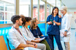 © unai - Medical team discussing patient information using smartphone in hospital corridor