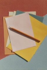 Poster - Minimalist Flat Lay of Colored Paper Sheets with Wooden Pencil on Textured Surface for Creative and Office Productivity Digital Content