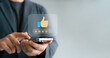 © Thapana_Studio - satisfaction engagement digital, Man using smartphone to give five-star rating with thumbs-up icon, representing positive customer review, feedback, mobile user experience.