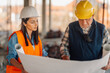 © Ljustina - Construction workers examining blueprint on building site