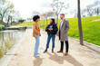 © Koldo_Studio - Three young professionals enjoying a conversation in a city park, discussing business and networking in a relaxed outdoor setting