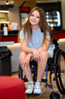 © luengo_ua - Young Woman in a Wheelchair Sitting in a Modern Coffee Shop Environment
