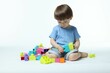© New Africa - Cute little boy playing with building bricks on white background