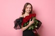 © New Africa - Smiling woman with bouquet of roses on pink background