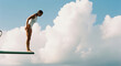 © Zamurovic Brothers - Woman in White Swimsuit on Diving Board Against Cloudy Sky