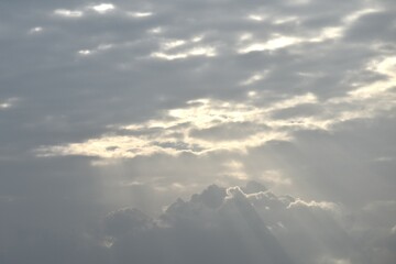 Wall Mural - sun spreading light thourgh dark rain cloud floating on sky at sunset in evening