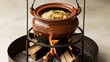 © FlexFlow - a traditional clay pot cooking over a fire made of firewood.