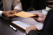 © Wasan - Lawyer receiving envelope with money for bribery. Corrupt lawyer receiving a bribe in an office, showcasing unethical behavior in law and finance. Hands accept money envelope.