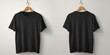 © Stock by Hemal - A High Resolution image of mockup of black t-shirt, front and back view, hangs on wooden hanger. Clothes template for design. Apparel advertising concept. Blank tshirt for branding.