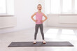 © New Africa - Happy girl standing on yoga mat indoors