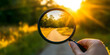 © Andsx - Hand Holding Magnifying Glass Showing a Scenic Sunset Path