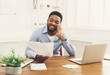 © Prostock-studio - Satisfying call. Young black businessman talking on mobile phone and reading report in modern white office, copy space