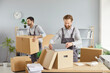 © Studio Romantic - Moving delivery pack service, male movers team moving cardboard boxes, loading, unloading setting up of household goods, new house stuff, carrying stacks of cardboard relocation boxes in office room