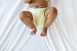 © Prostock-studio - Cropped Shot Of Little African American Baby Wearing Reusable Diaper Lying On Bed, Bottom Part Of Unrecognizable Black Infant Boy Or Girl Resting On White Bedsheet In Bedroom, Top View